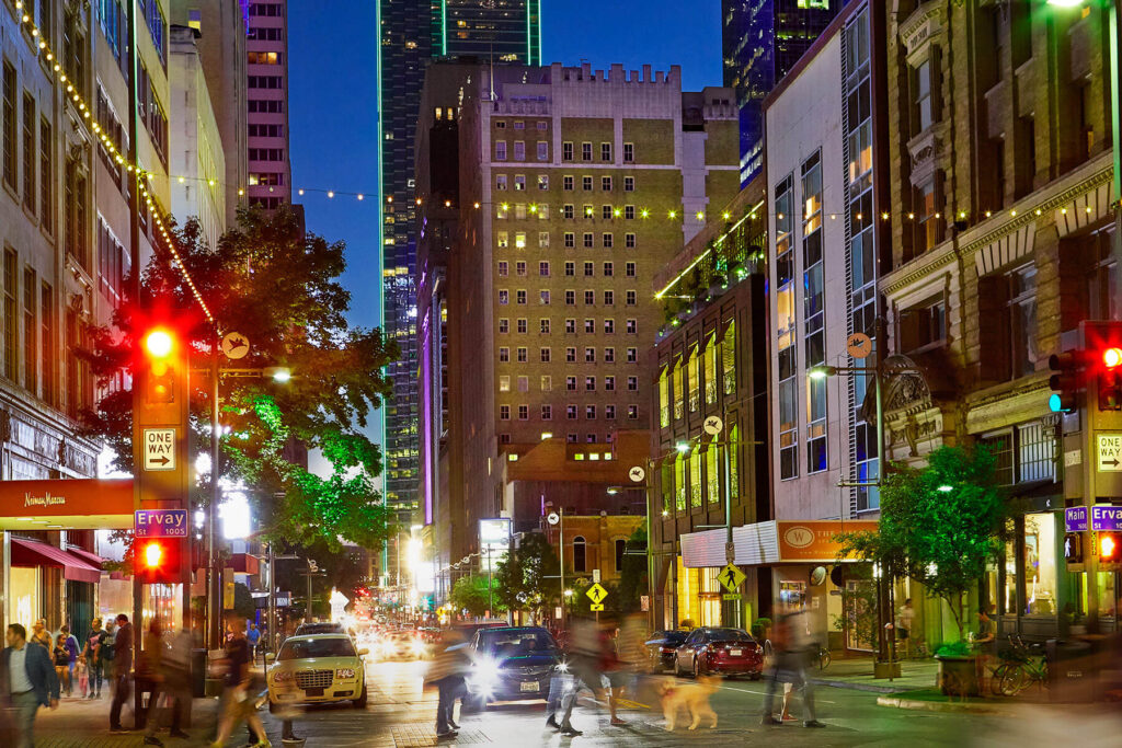 Cost of living in Dallas TX - downtown street scene with illuminated buildings and bustling nightlife