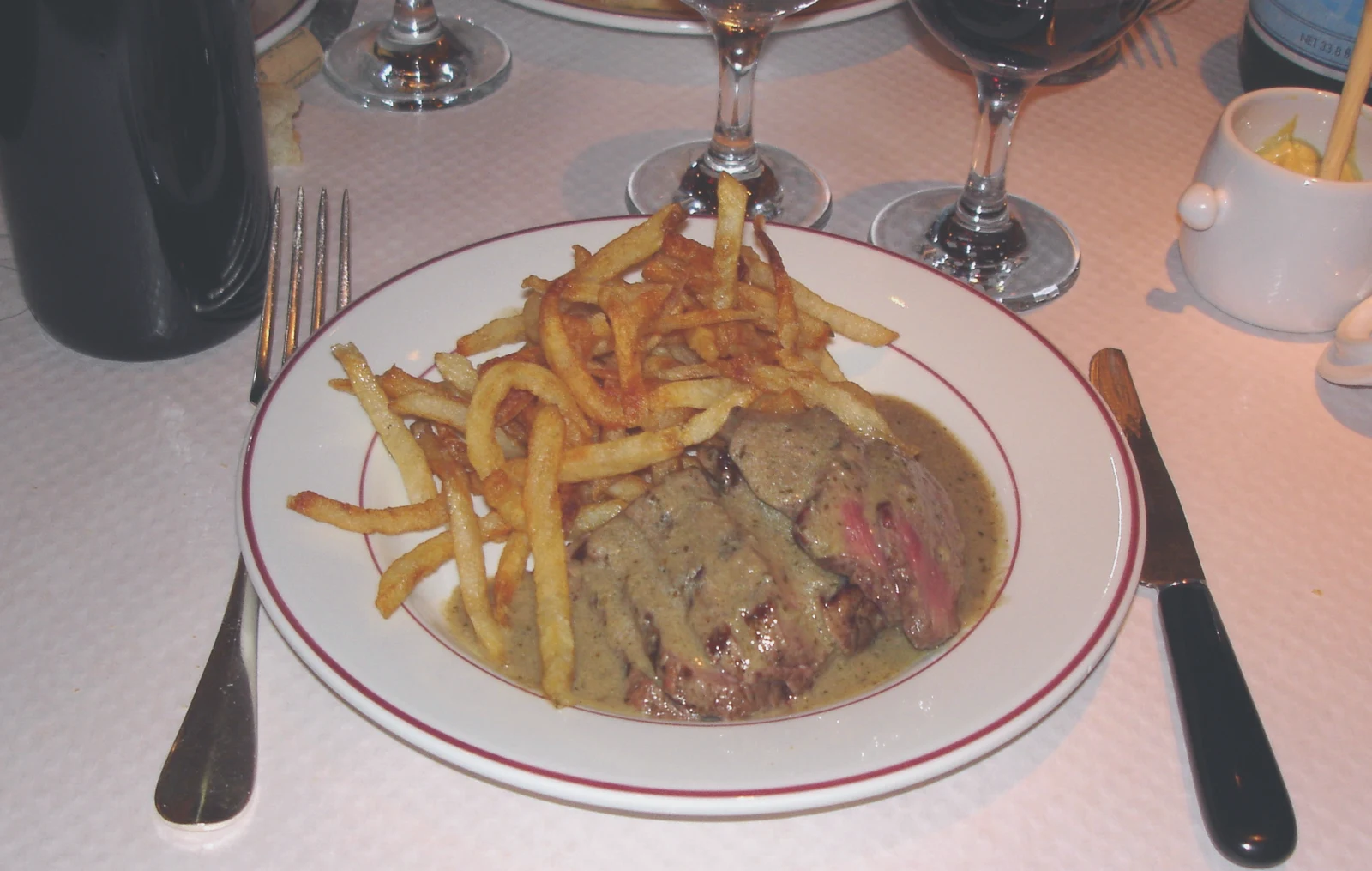 A classic steak frites plate with sliced steak and golden French fries