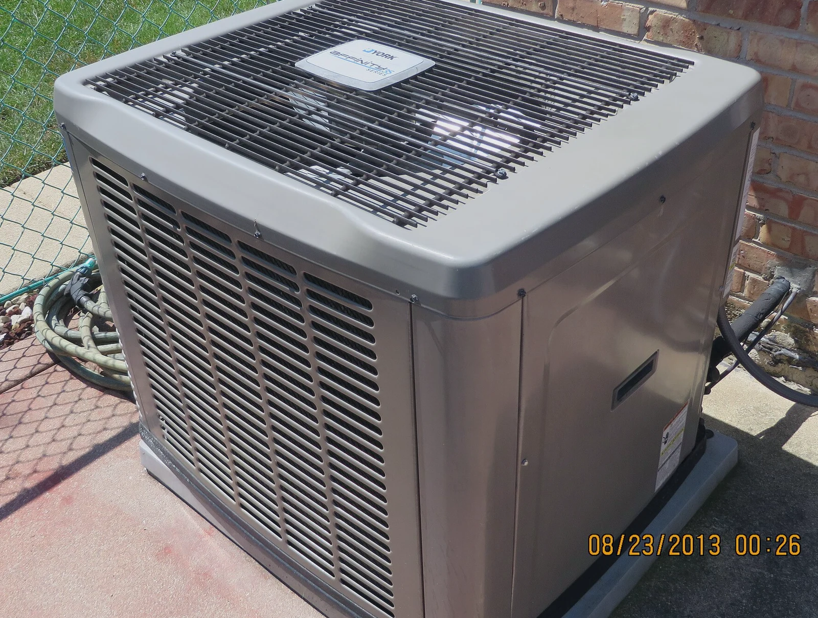 Residential air conditioning condenser unit outside a home, the kind Dallas HVAC companies service in summer